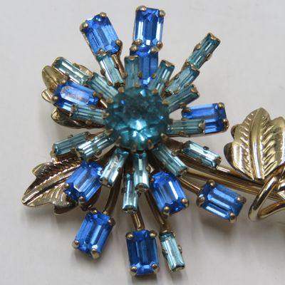 Starburst Flower brooch with aqua and blue rhinestones manufactured by Norman Hartnell - dressmaker to Queen Elizabeth II and the Queen Mother