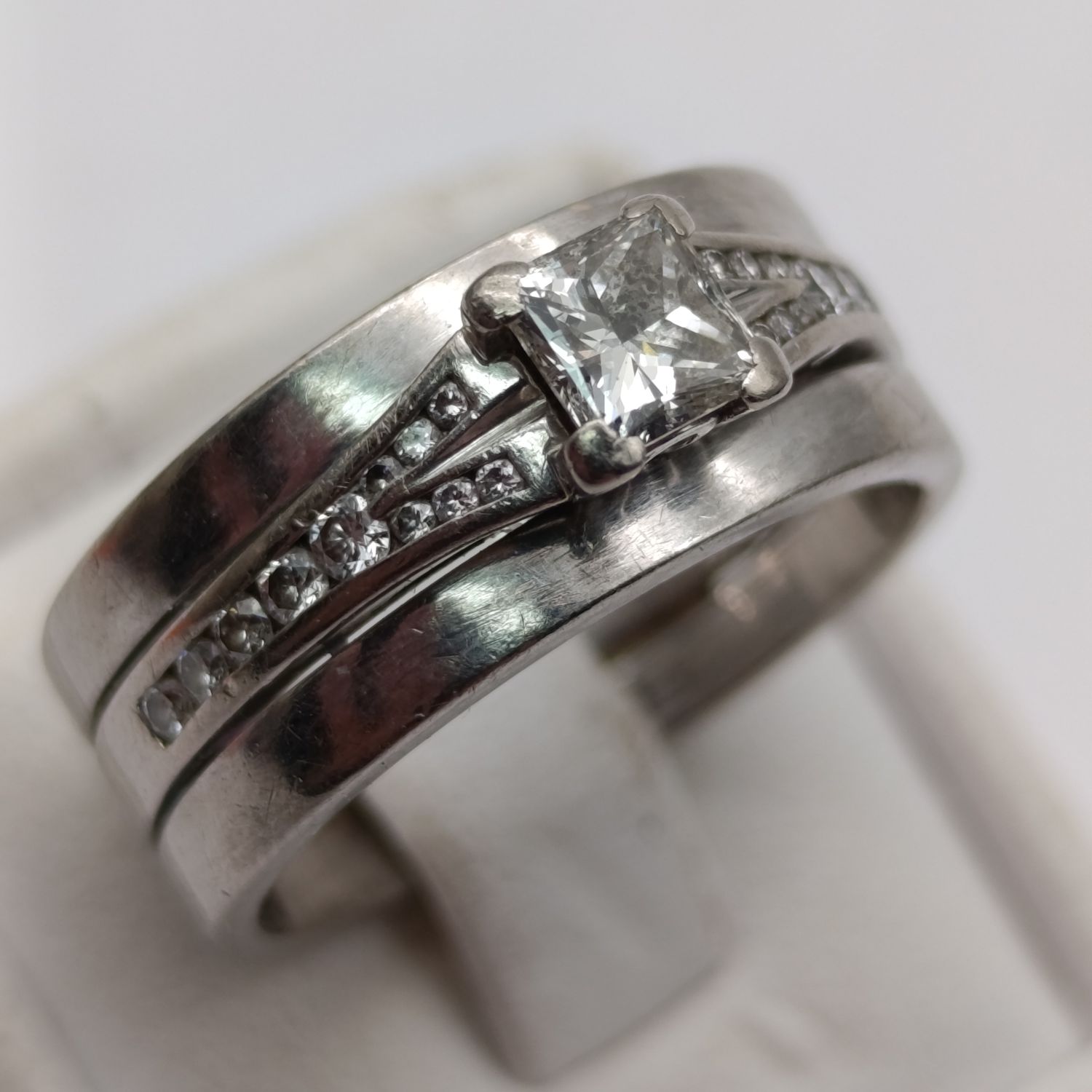 18kt white gold ring with princess cut diamond of about 40 points and 22 smaller diamonds - size P