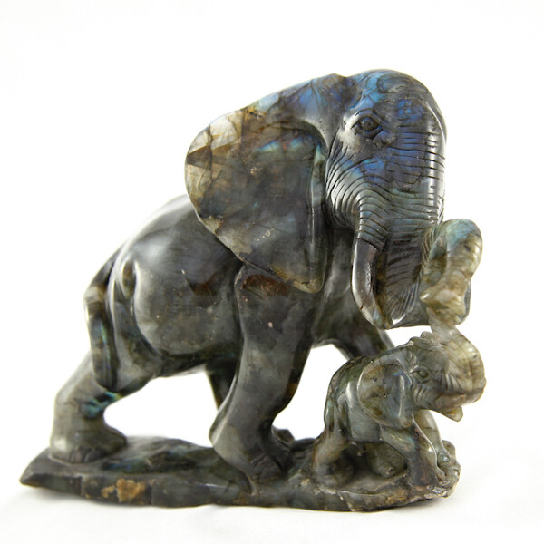 Photo of a Labradorite Elephant with vibrant iridescence, showing colors like blue, green, and gold. Each unique piece captures light, adding charm to any collection. Disclaimer: Stone color, size, or shape may slightly vary from image. Each order is randomly chosen by The Crystal Shrine staff.