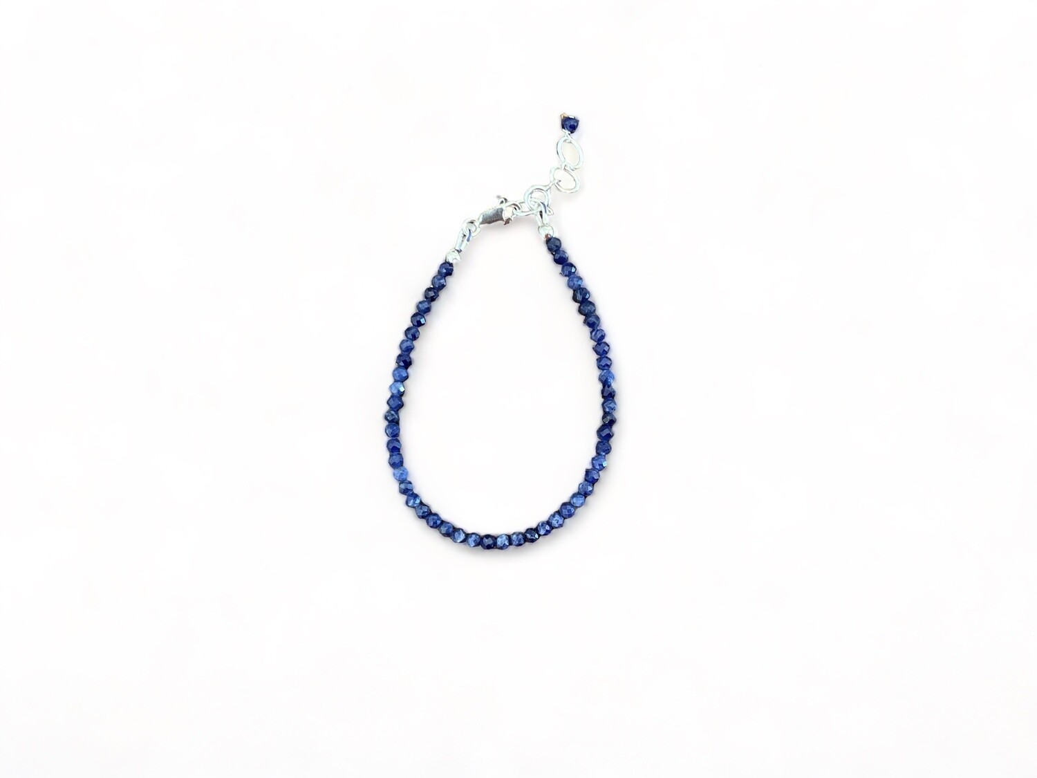 Photo of a beaded sodalite bracelet featuring deep blue 2mm faceted beads and a sterling silver clasp. Designed to promote calm and support meditation practices. It measures 6.5 inches long with a 1 inch sterling silver extender chain.