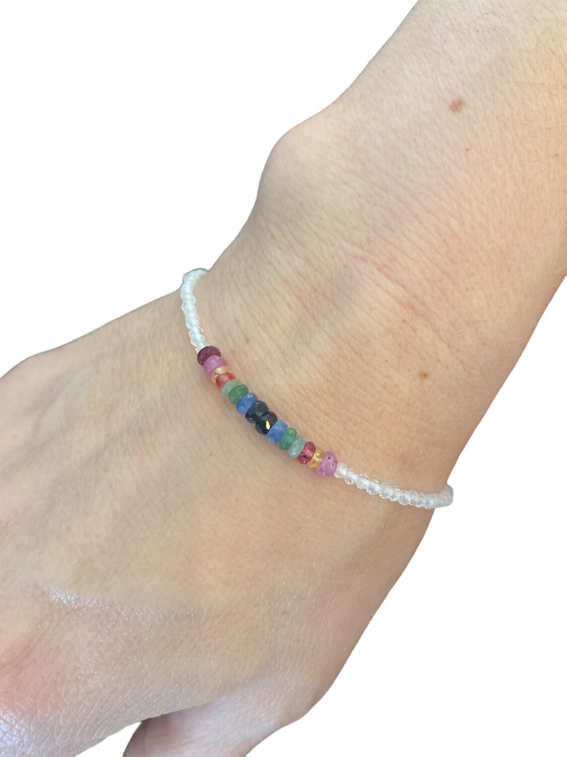 Photo of a white topaz bracelet with 2mm faceted beads, accented by ruby, emerald, and sapphire gemstones. Each gem represents support, fidelity, strength, and wisdom. This dazzling band measures 6.5 inches long with a 1 inch sterling silver extender chain.