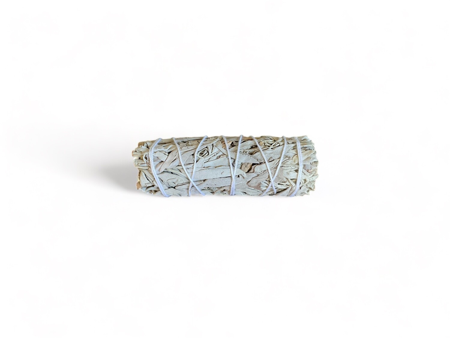 Photo of a mini four inch white sage smudge bundle. The bundle is tightly wrapped with twine, showcasing a compact and neat arrangement of sage leaves. Designed for energy purification and metaphysical practices, this bundle is ideal for spiritual and ceremonial use.