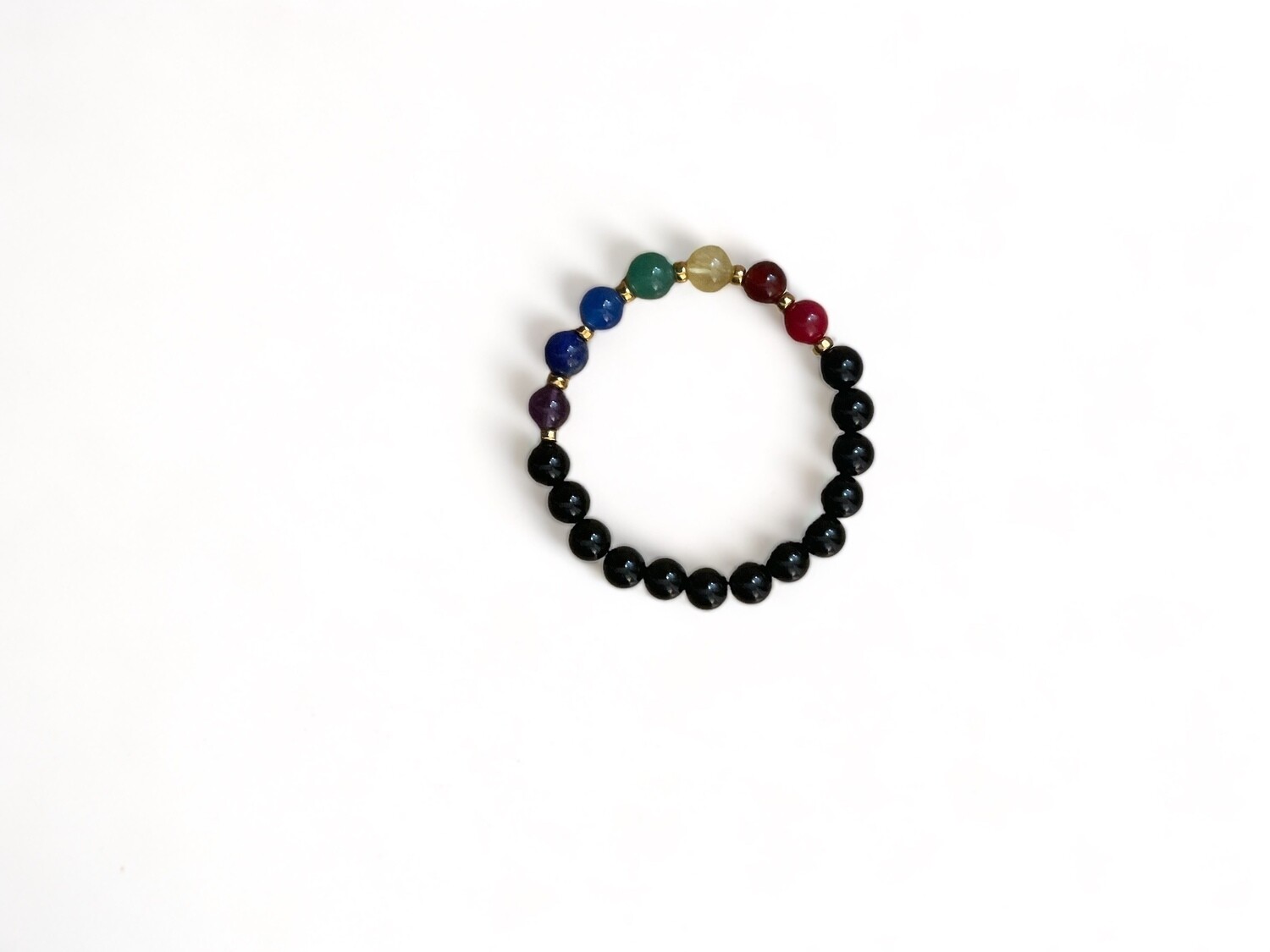 Photo of a 10mm Premiere 7 Chakra Bracelet featuring Black Agate crystal and colorful chakra beads. The bracelet is designed to offer protection, courage, and emotional balance.