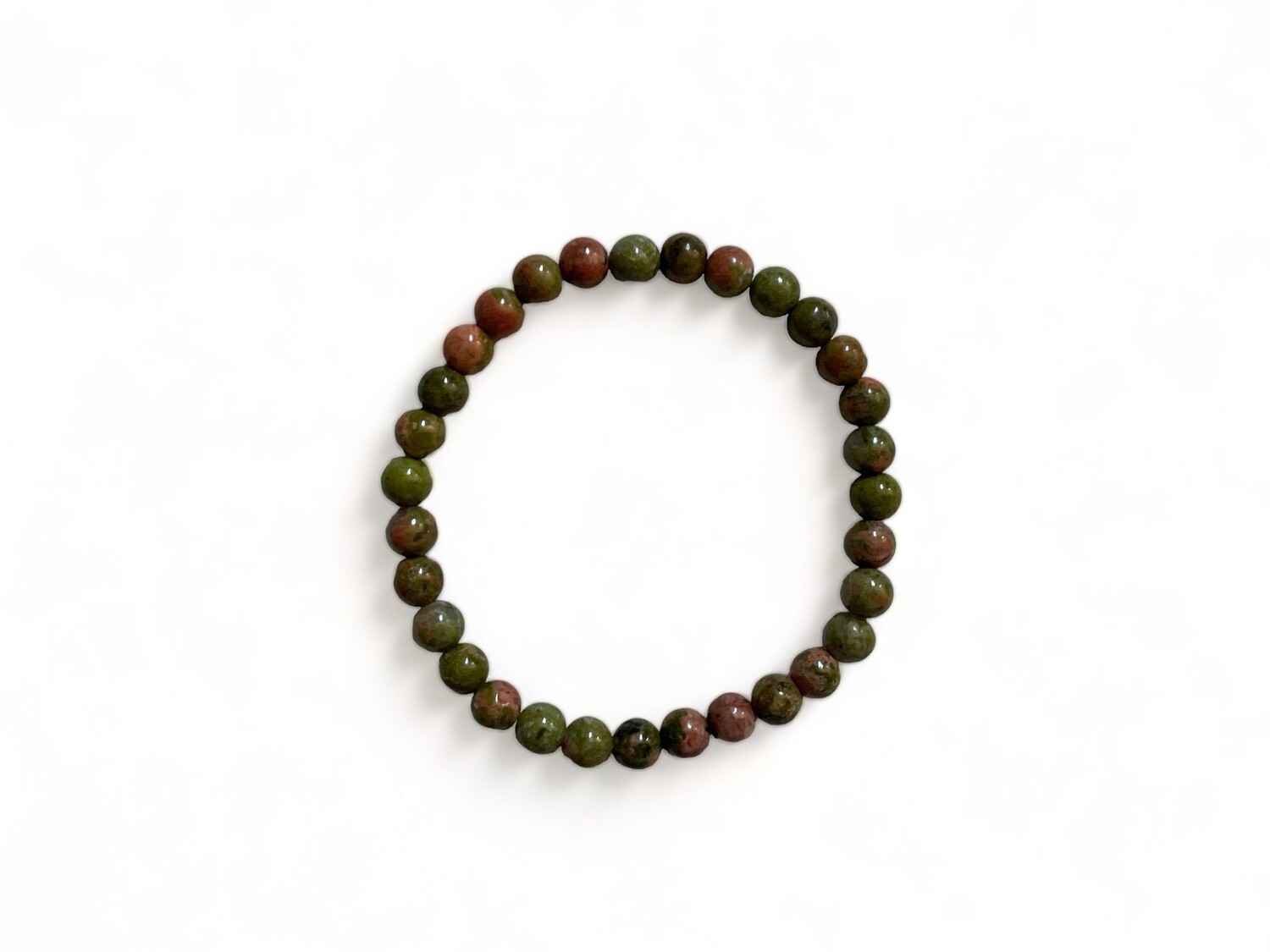 Photograph of a 6mm Unakite bracelet featuring mottled green and pink beads. This beautiful gemstone bracelet is designed to support emotional healing, balance, and personal growth.