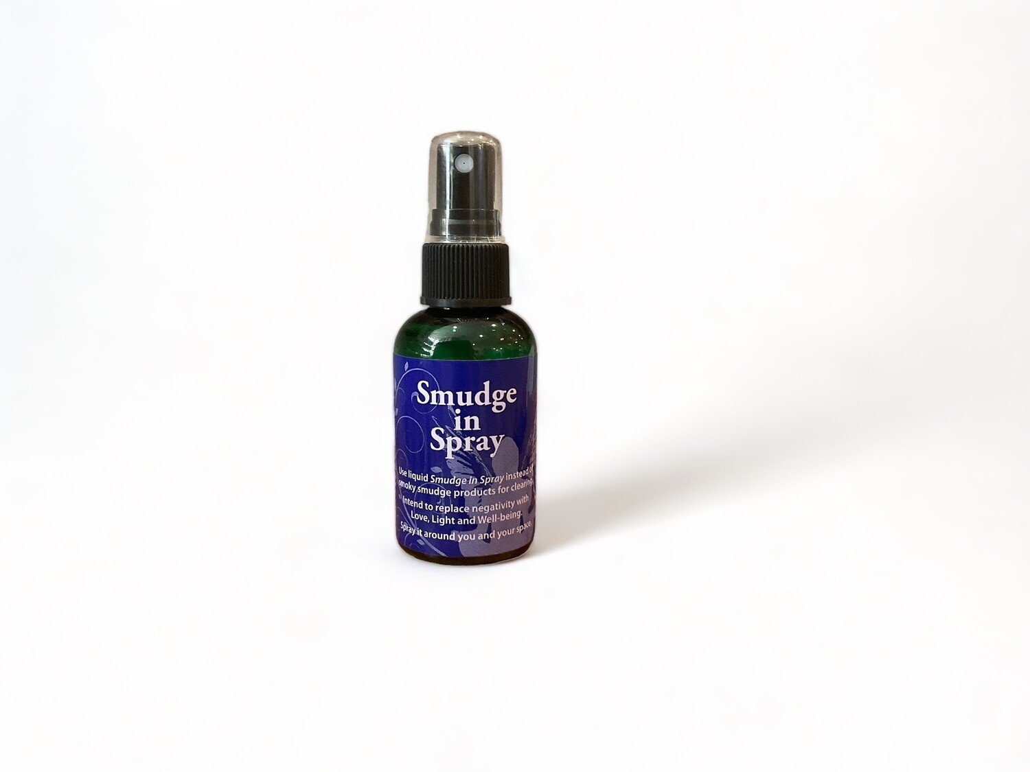 Smudge Spray two ounce bottle designed for clearing negativity and enhancing energy. The bottle features a label with the product name and description, set against a simple background. The liquid inside is clear. This spray offers a smokeless alternative to traditional smudging, ideal for purifying spaces and personal energy. Suitable for use in homes, offices, or personal spaces to foster a positive environment.
