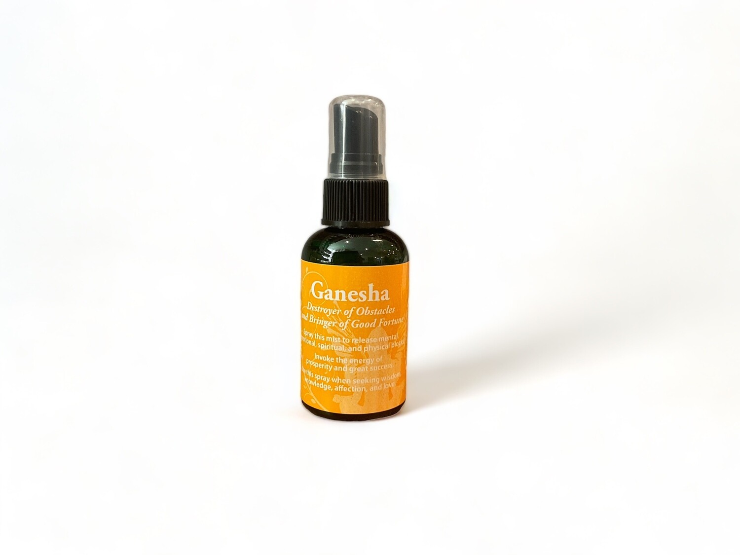 Image of a two ounce bottle of Ganesha Spray. Thebottle features a label with &#39;Ganesha Spray&#39;. The label highlights its purpose for releasing obstacles and inviting prosperity. It is designed for use on yourself or in your space, invoking the energy of success and abundance. The design reflects its mystical and sacred qualities.