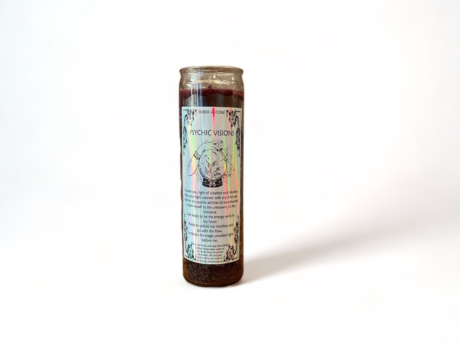 A glass jar holds the Psychic Visions Candle, labeled &#39;Psychic Visions&#39;. This intention candle enhances intuition and promotes psychic clarity, ideal for spiritual practices.