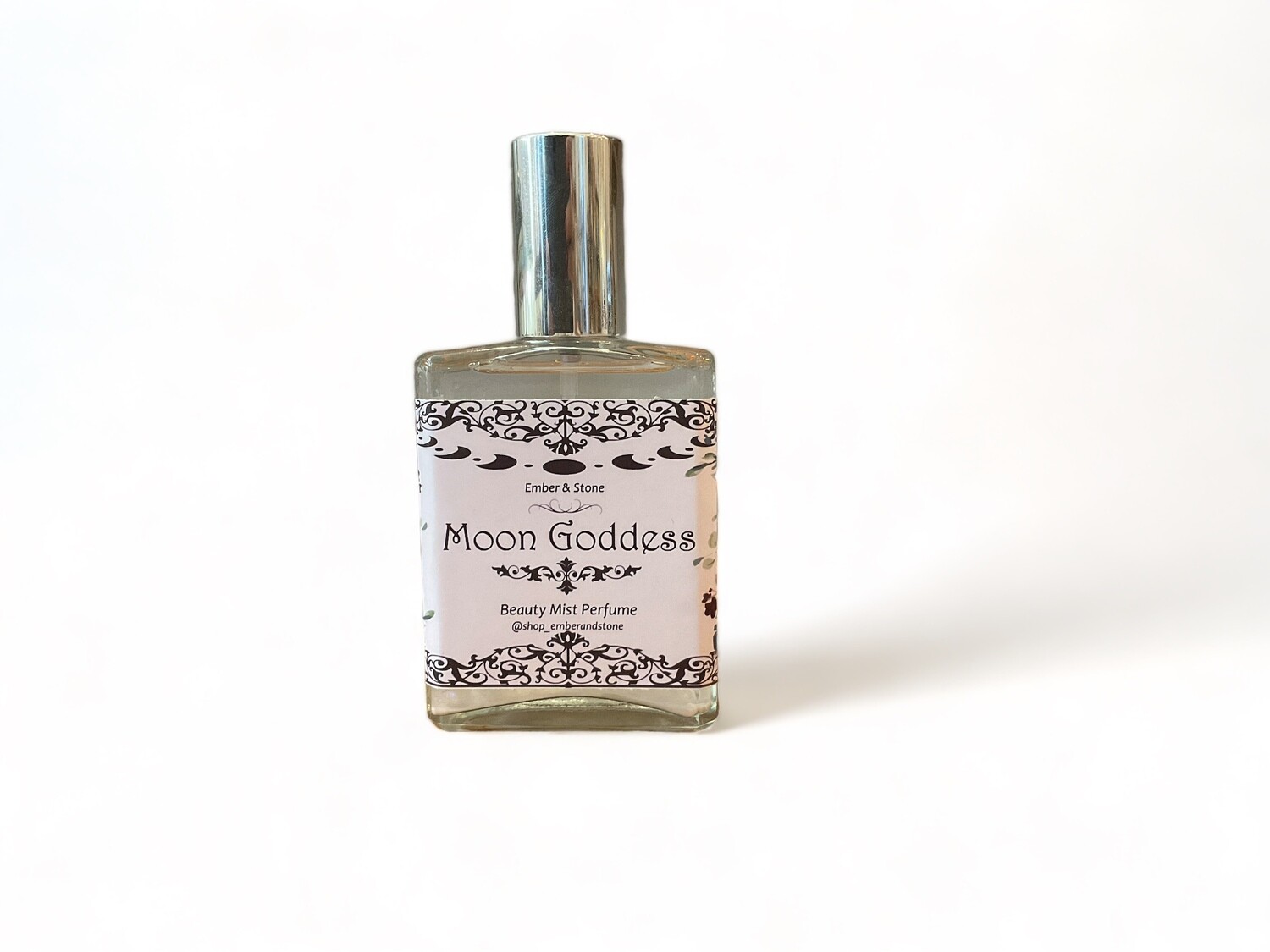 Image of Moon Goddess Perfume, a sweet and floral beauty mist. The clear glass bottle contains a light-colored liquid and is labeled with elegant text. The bottle features a spray top for easy application. It is designed for personal use or to refresh spaces, adding a charming scent and a touch of serenity. 