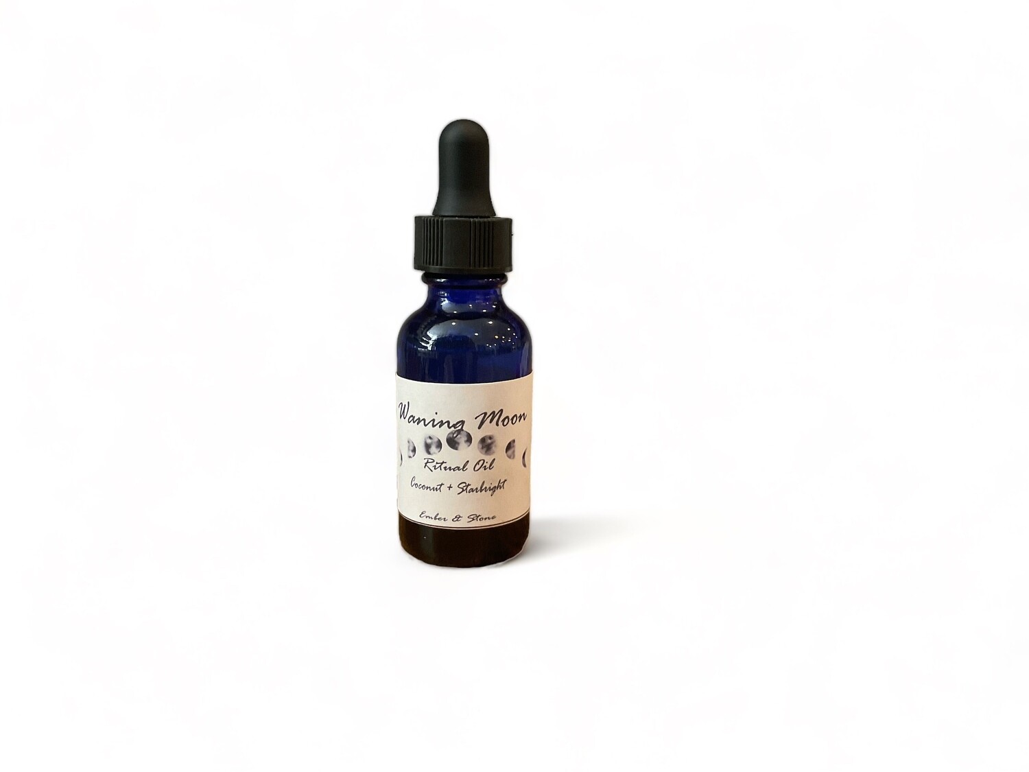 Photo of Waning Moon Oil, featuring a blend of coconut and starlight. The is labeled for ritual use. The bottle is equipped with a dropper cap for precise application. This oil is designed for intentional use, including applying to stones, candles, and journals, or adding to baths and diffusers. 