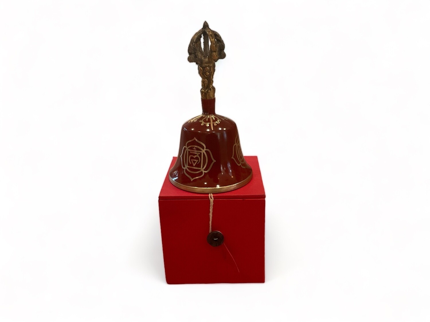 Image of a Red Root Chakra Tibetan Bell, 5.5 inches, paired with a striker. The bell features a vibrant red color with intricate golden detailing. It produces a deep, resonant sound when struck, ideal for grounding and stability. The striker is used to ring the bell, complementing the bell&#39;s design. This set is intended for clearing space and balancing the root chakra.