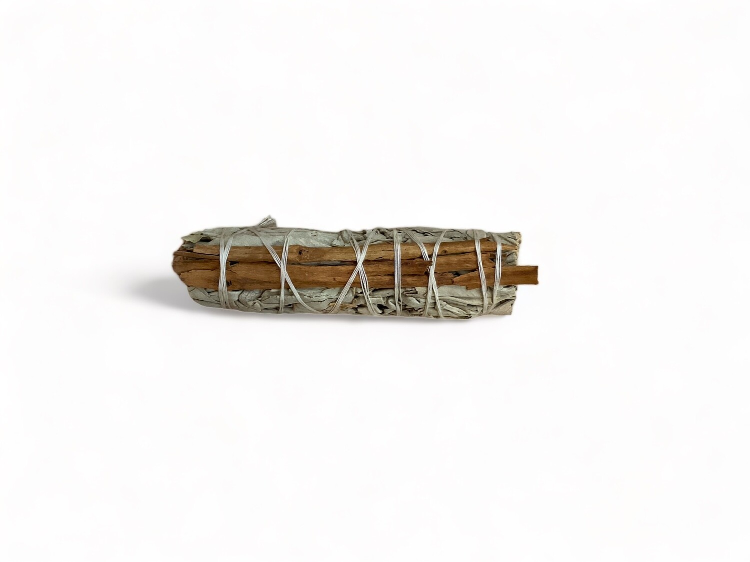 Image of a four inch bundle of white sage and a cinnamon stick, tied together with a string. The white sage has silvery-green, aromatic leaves, while the cinnamon stick is a rolled, brown spice. This combination is used in rituals for purification, protection, and enhancing intuition, aiming to promote positive energy and spiritual clarity.