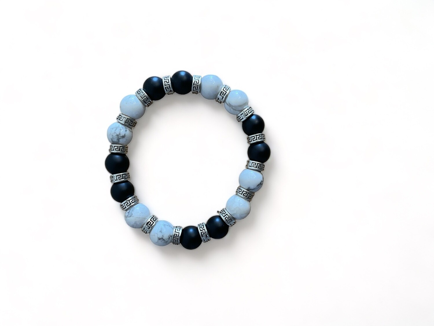 Photo of a bracelet with 10mm black matte howlite beads and silver accents. Designed to enhance calm and focus, combining style with grounding properties.