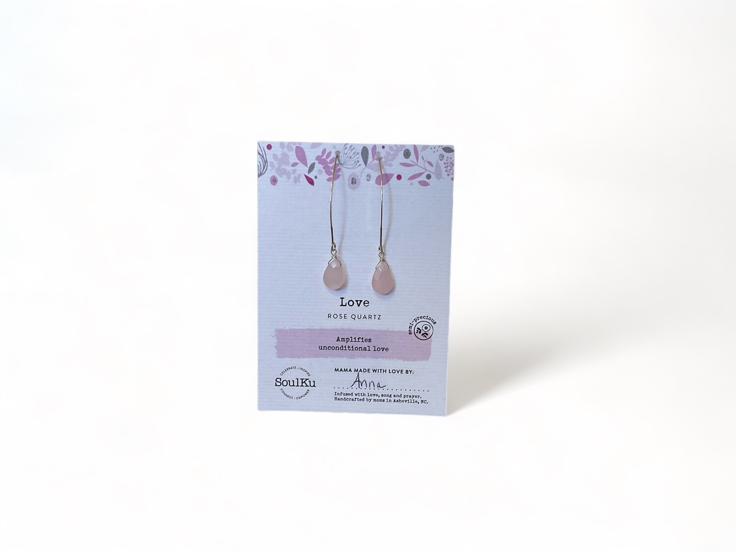 Photograph of long earrings featuring smooth, soft pink Rose Quartz crystals set in delicate golden hooks. Designed to promote calm, emotional healing, and balance.