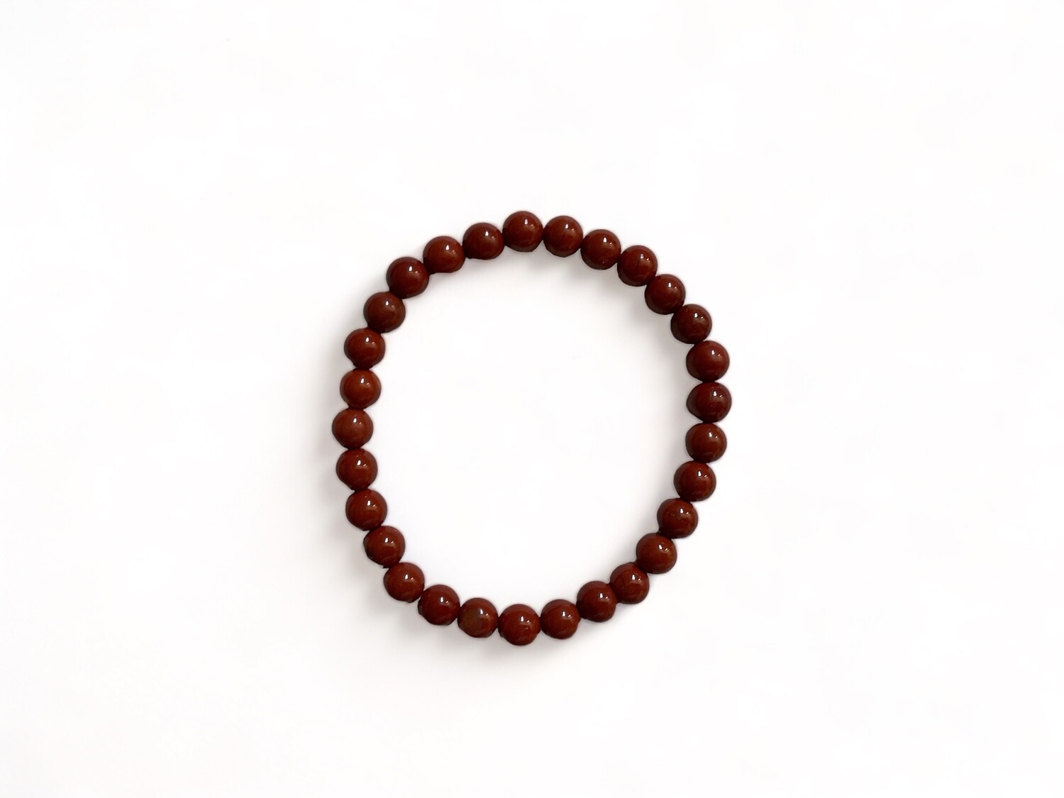 Close-up photo of a 6mm Red Jasper bracelet with deep red beads. This gemstone bracelet is recognized for its grounding energy and is suitable for daily wear.