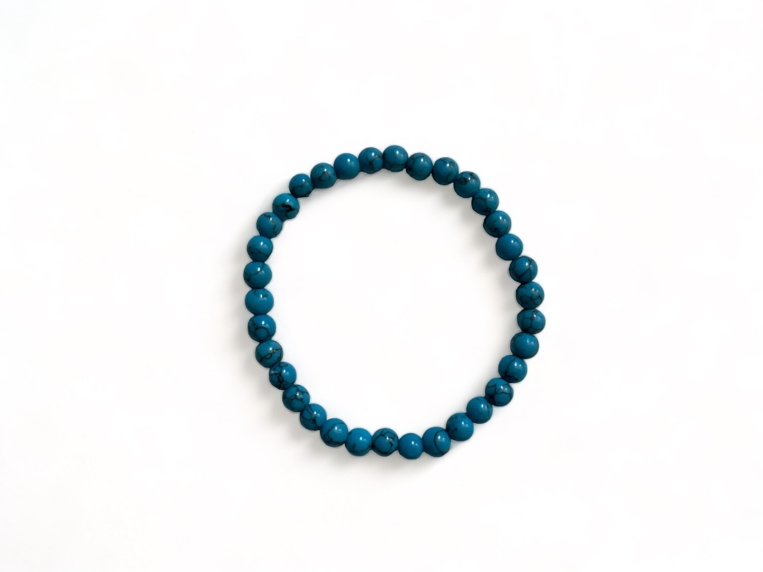 Close-up image of a 6mm Howlite crystal bracelet. This stylish metaphysical bracelet is designed for stress relief, emotional balance, and enhanced communication.