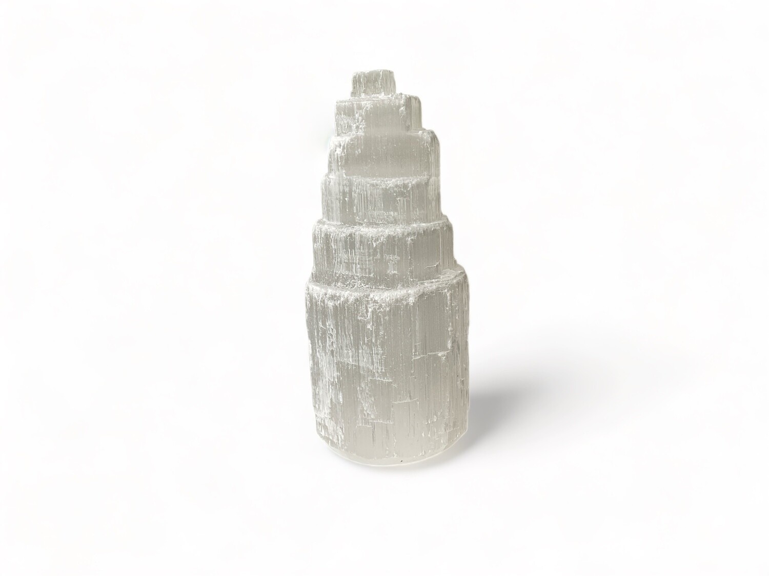 Image of a 4” Selenite crystal tower with a sleek design, known for its purifying energy. Ideal for meditation, energy clearing, and enhancing spiritual practices. Disclaimer: Stone color, size, or shape may slightly vary from image. Each order is randomly chosen by The Crystal Shrine staff.