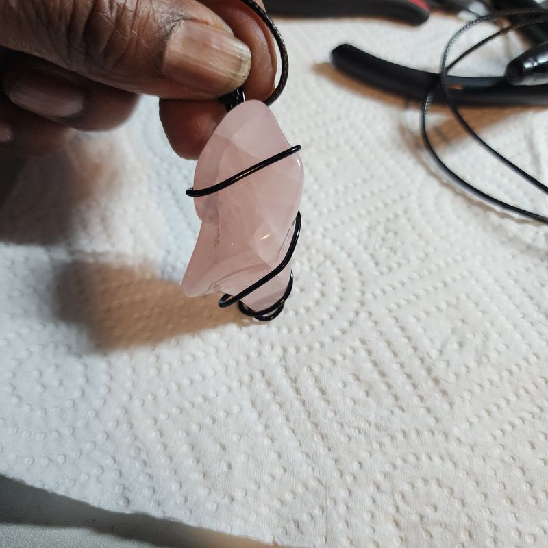 Rose quartz crystal wrapped in black wire