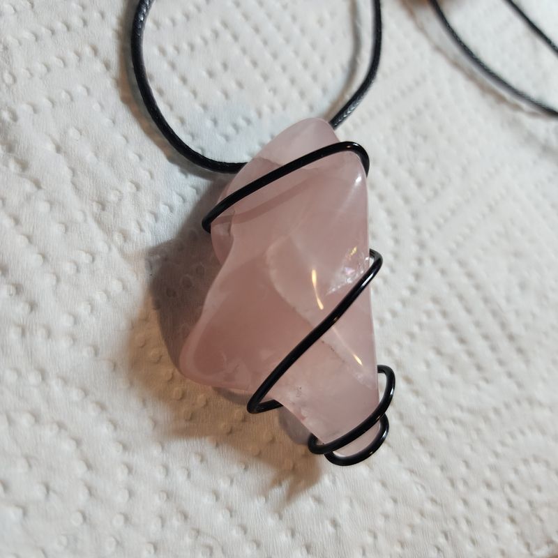 Rose quartz crystal wrapped in black wire