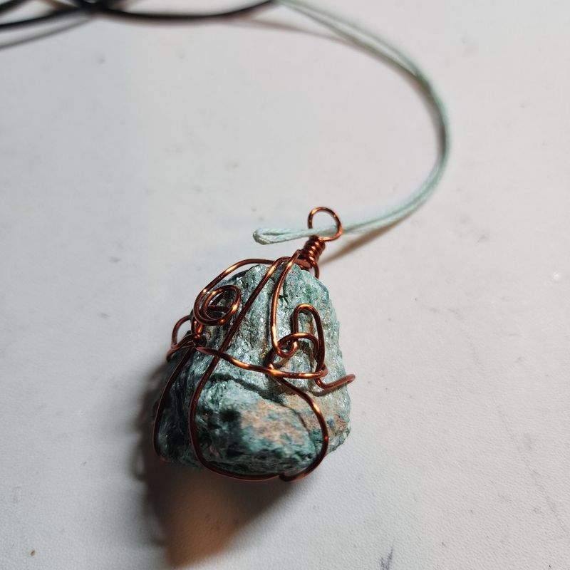 Fushite wrapped in bronze wire on blue cord