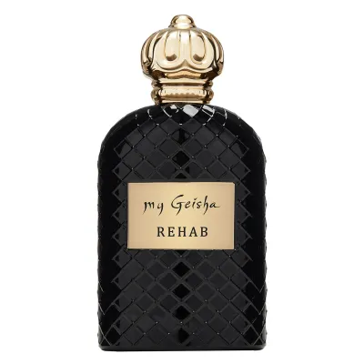The content is of a black and gold luxury perfume bottle on white background. The bottle has a golden cap featuring arabic gold pattern and has a gold label in the centre which has engraved in black letters the text &quot;my Geisha Rehab.&quot; The additional context mentions &quot;my Geisha Rehab Extrait de Parfum&quot; and other related terms like &quot;my geisha UK&quot; and &quot;my geisha perfume price.&quot; Tags include perfume, toiletry, spray, bottle, and cosmetics.