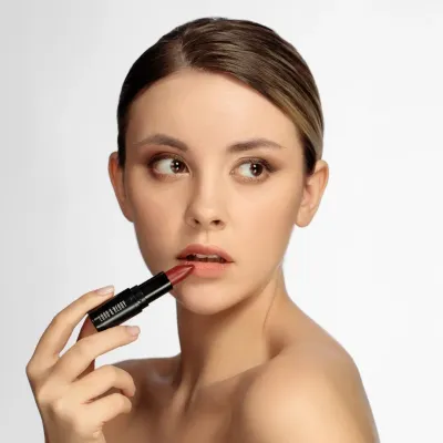 Close-up image of LORD &amp; BERRY lipsticks, elegantly presented by a stunning model against a sleek neutral background. The display highlights the brand&#39;s diverse range of vibrant shades and luxurious formulas, designed for all occasions. Explore premium cosmetics at mygeishamiltonkeynes.co.uk.