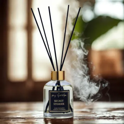 my Geisha Secret Stories reed diffuser with black reeds and golden cap, diffusing luxurious home fragrance in a warm, softly lit interior setting