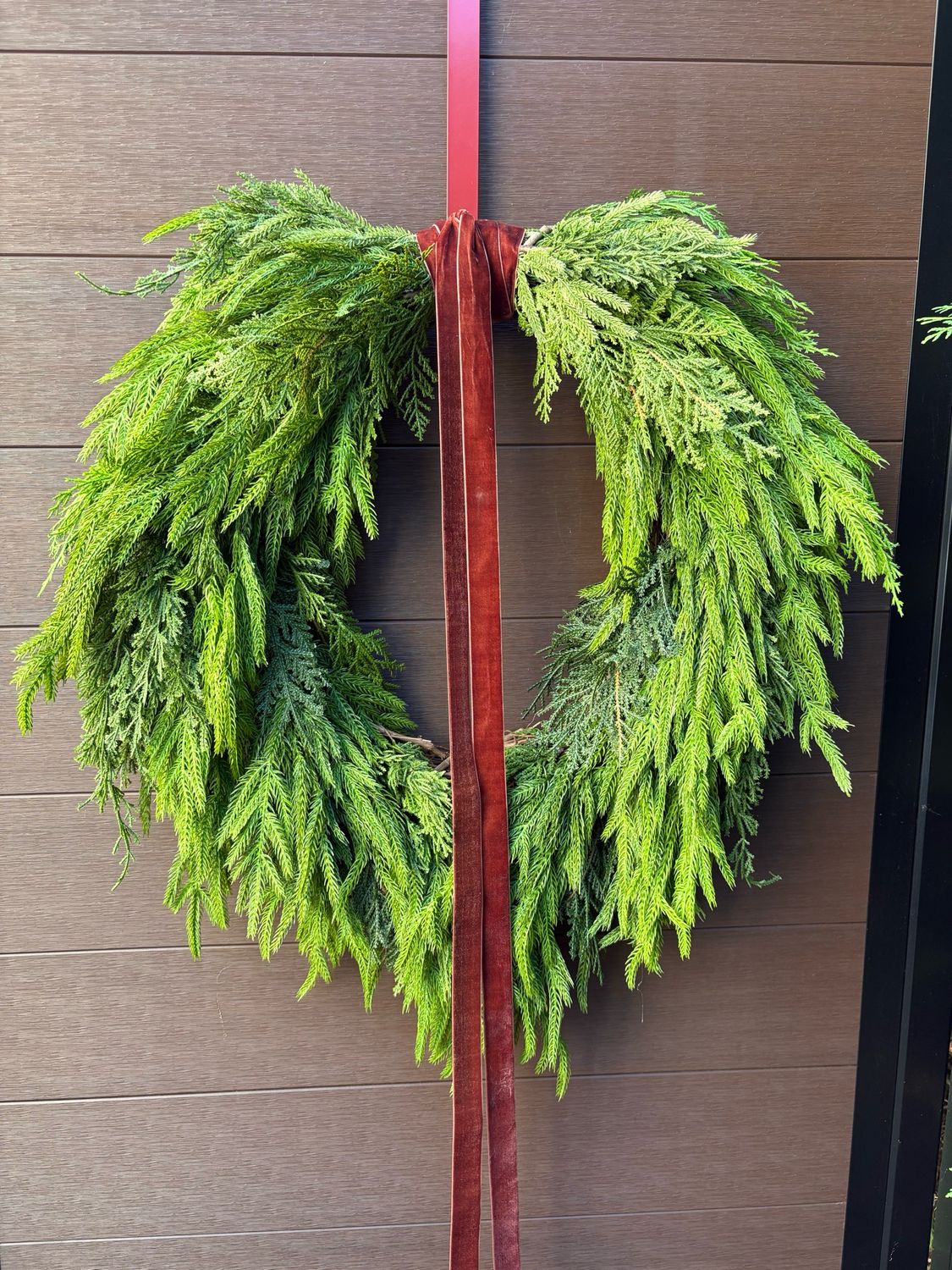 Couronne de Noël artificielle en pin Norfolk et cèdre – 16 po de vigne, 27 po de diamètre, ruban brun en velours