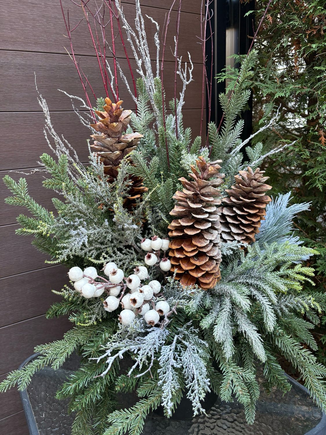 Arrangement d’hiver artificiel dans pot noir – Conifères, cocottes et baies blanches