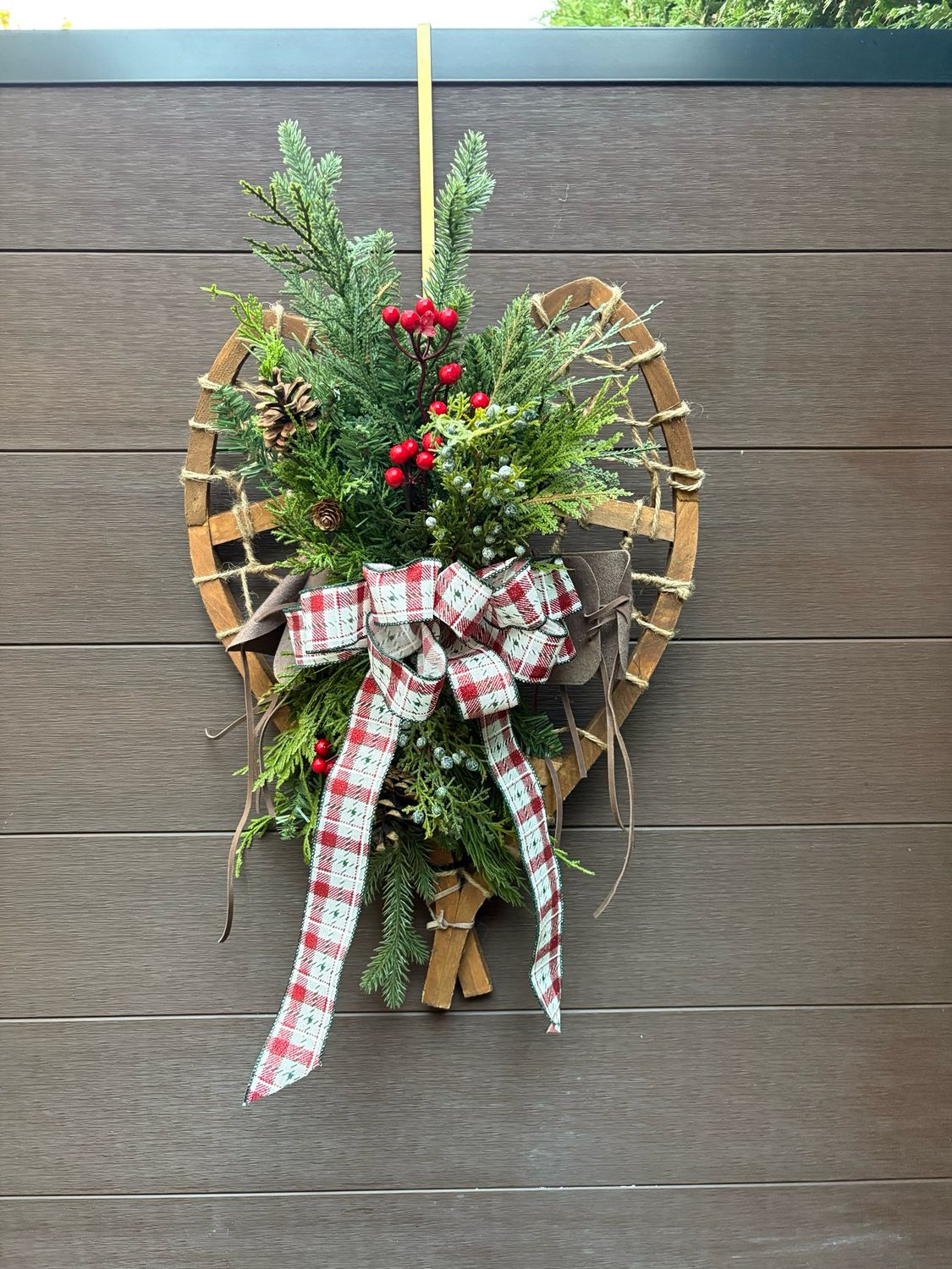 Décoration de Noël rustique sur raquette en bois – feuillage et ruban à carreaux 