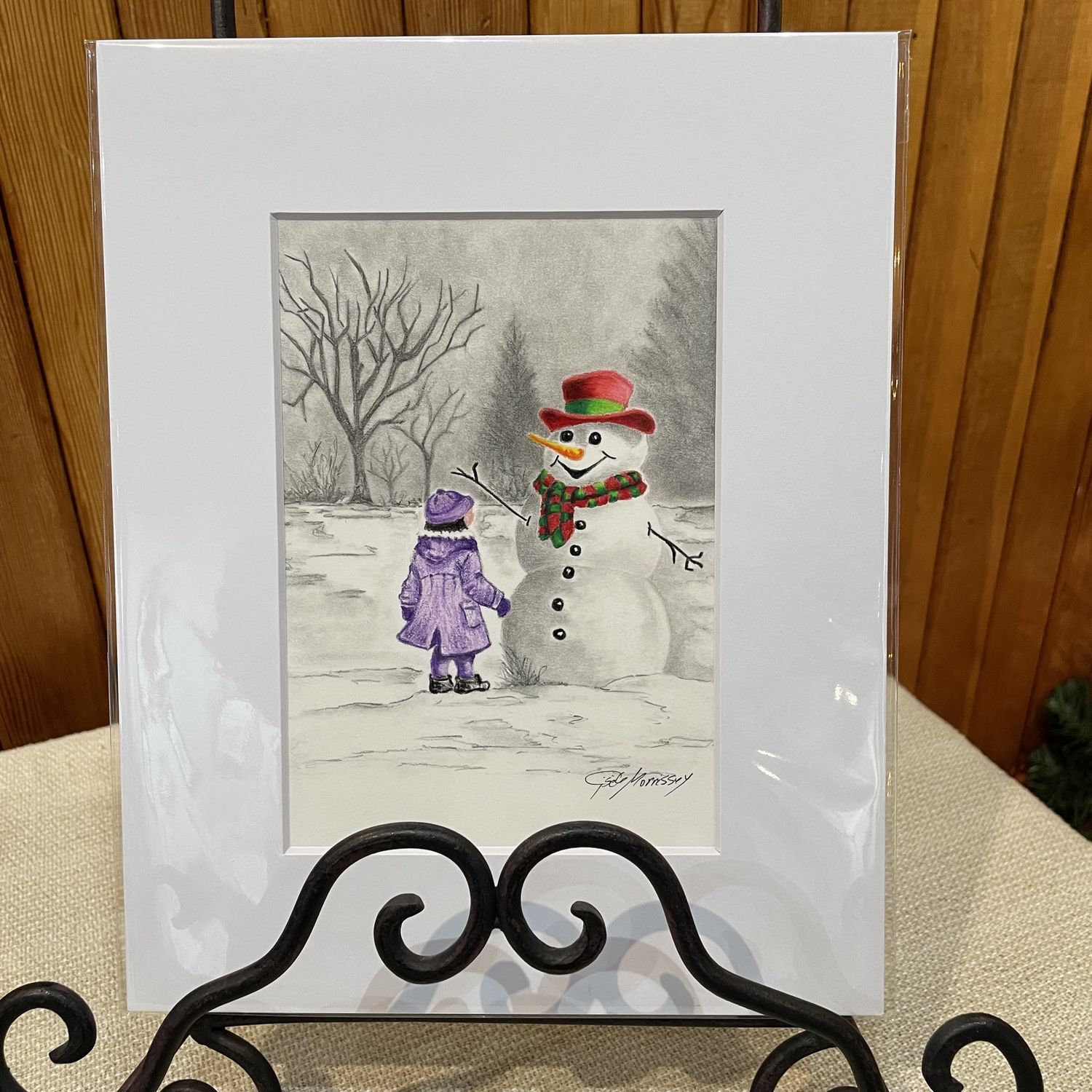 Snowman with little girl in purple coat