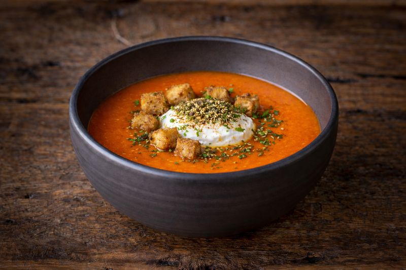 Soep van rode puntpaprika. croutons en labneh