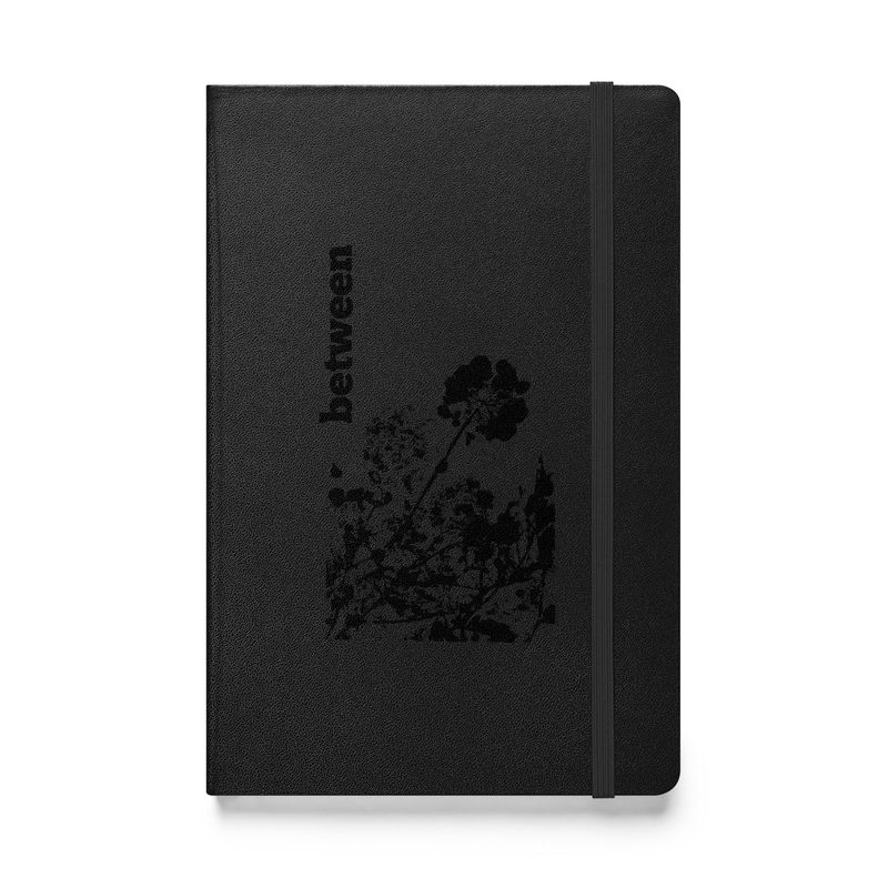 Between - Artist designed Hard cover notebook front view. Black color with black design print.