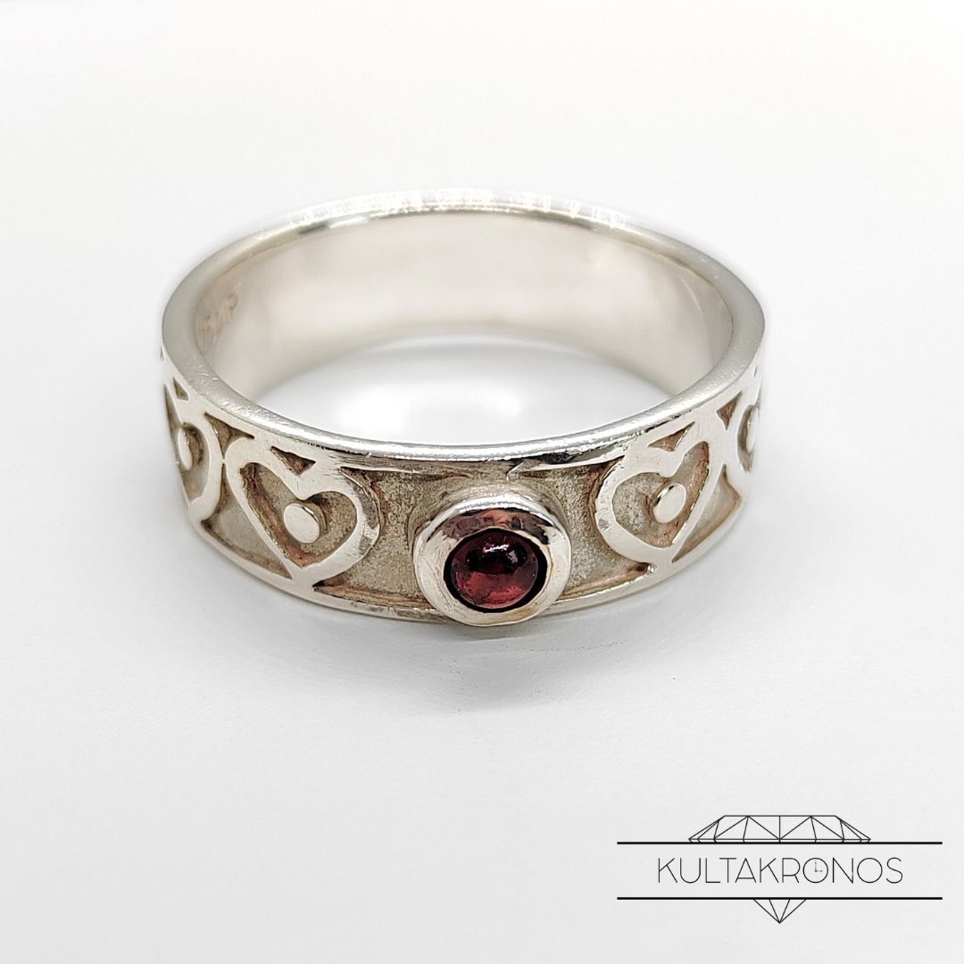 Sydänsormus punaisella kivellä