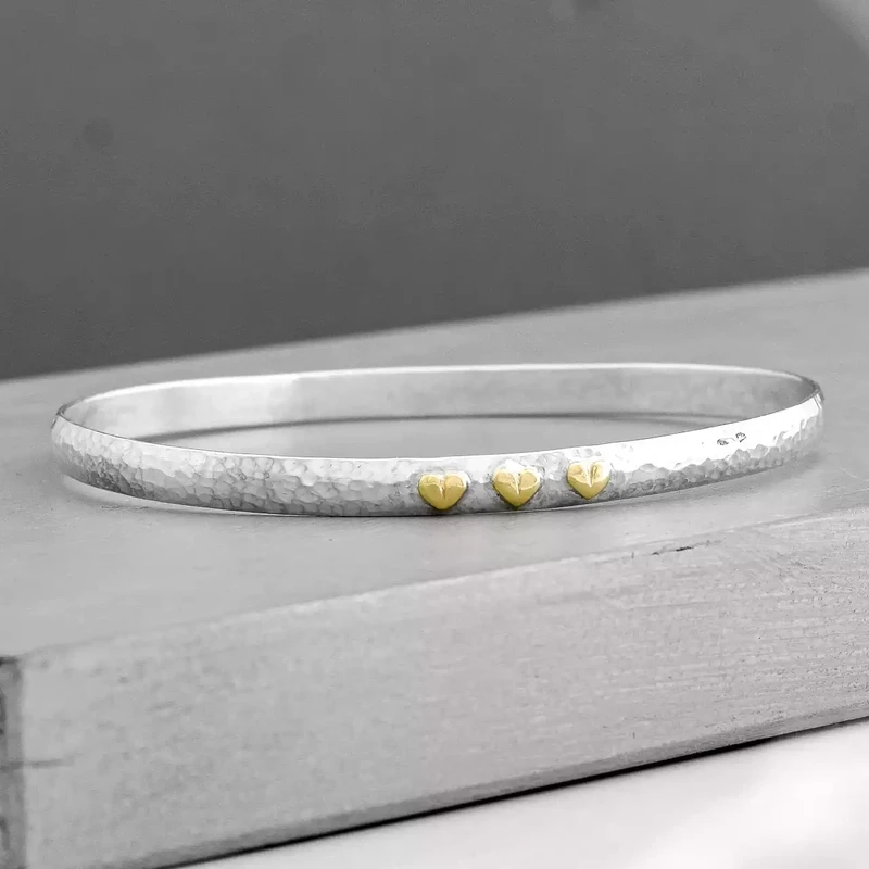 Beaten Silver Bangle With Three Gold Heart Charms by Fi Mehra