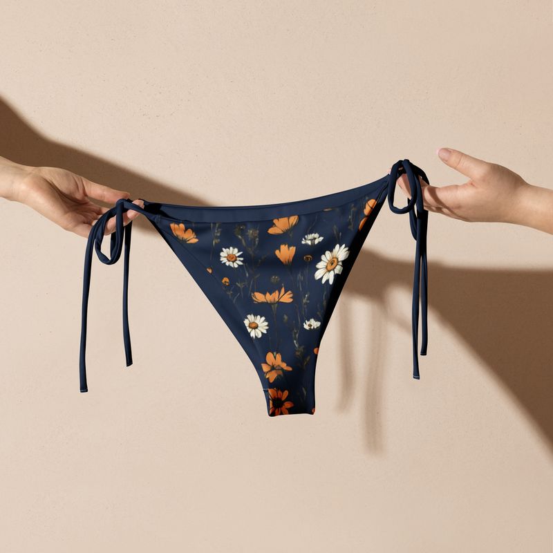 Navy blue string bikini bottoms have a stunning print featuring retro wild flowers. 