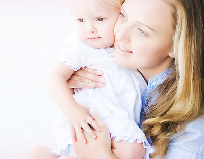 Mama mit Kind im Kleid auf dem Arm