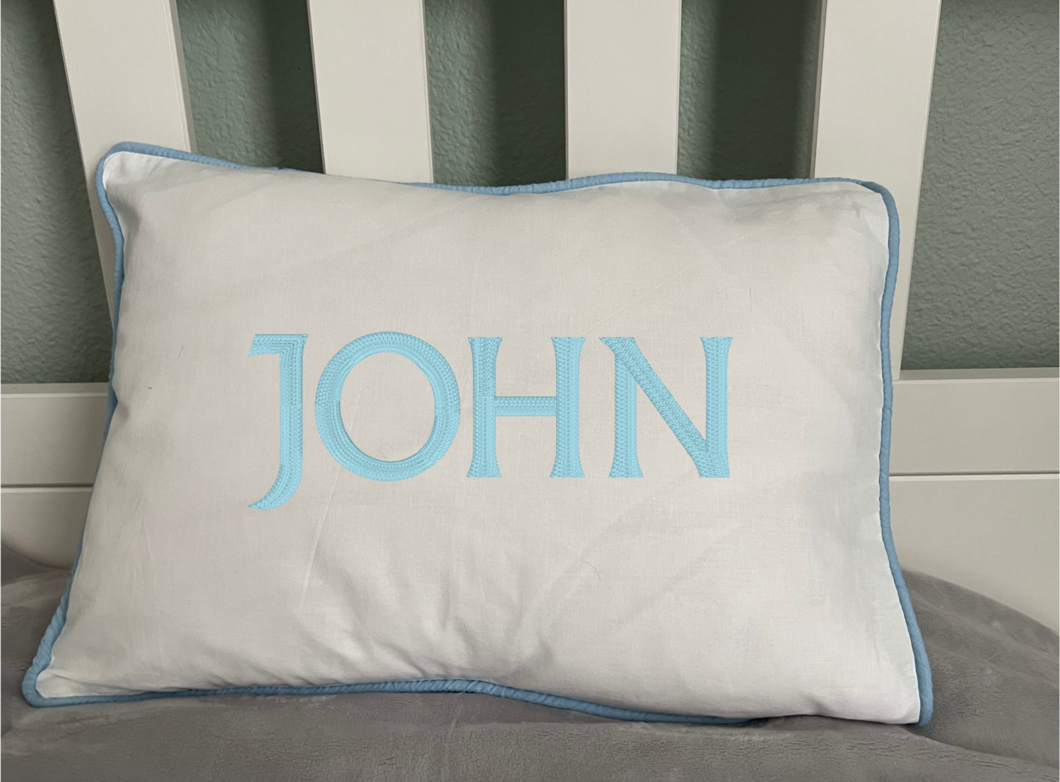 Nursery pillow with blue piping