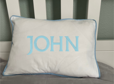 Nursery pillow with blue piping