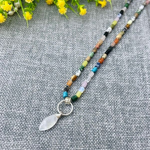 Handmade Necklace with mixed gemstones knotted on blue silk, and a rainbow moonstone on textured ring