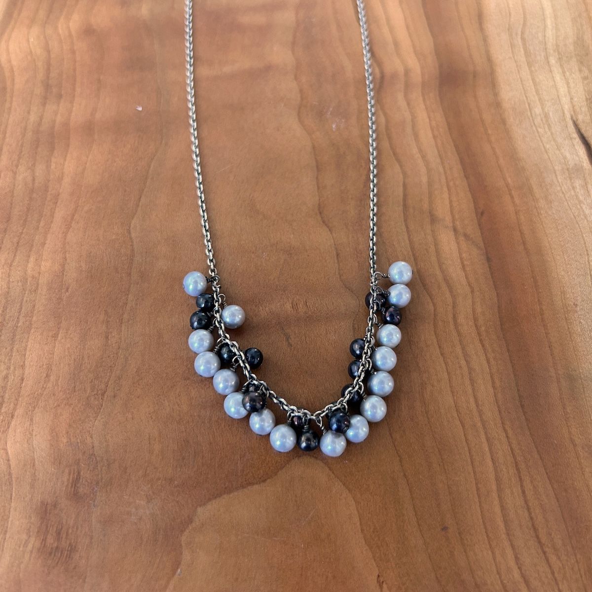 Handmade Necklace with dangle across white, grey, peacock pearls