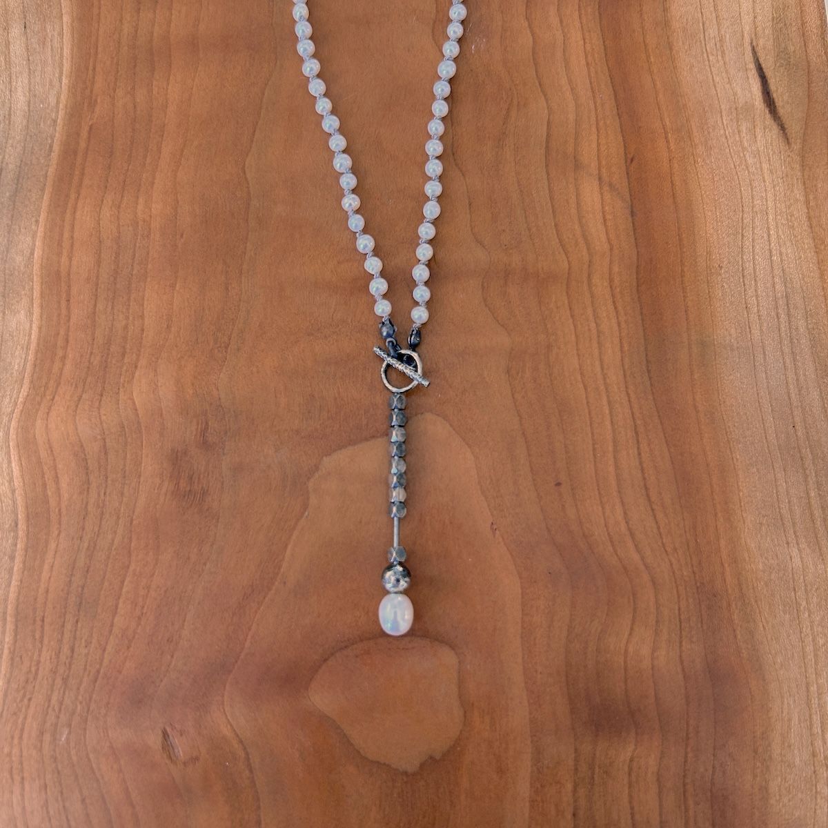 Handmade Necklace with white pearl knotted on grey silk, oxidized pendant