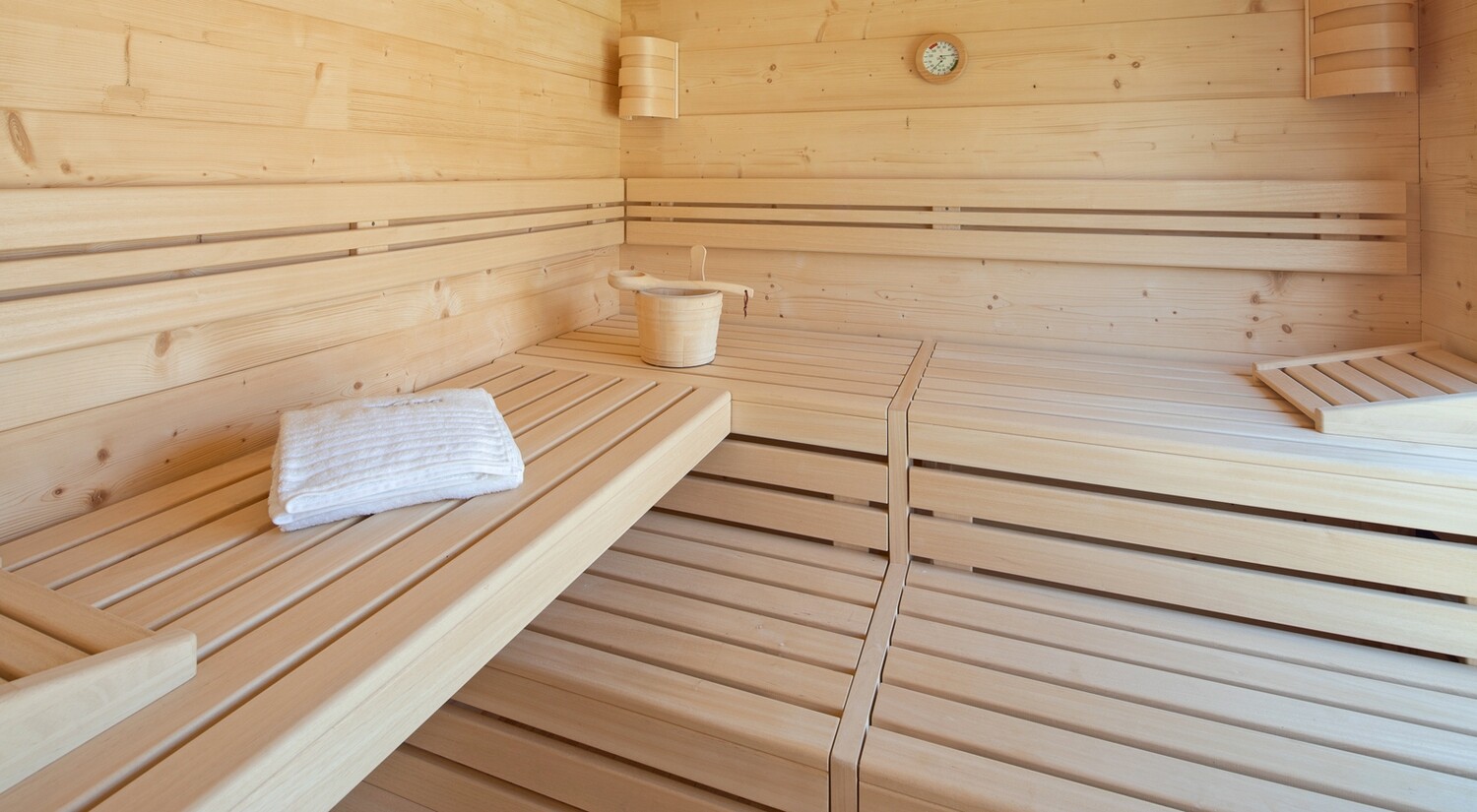 Blick ins Saunainnere mit EOS Euromax 12 kW Saunatechnik, integrierter LED-Beleuchtung und rustikalem Holzdesign – perfekte Kombination aus Technik und Natur.