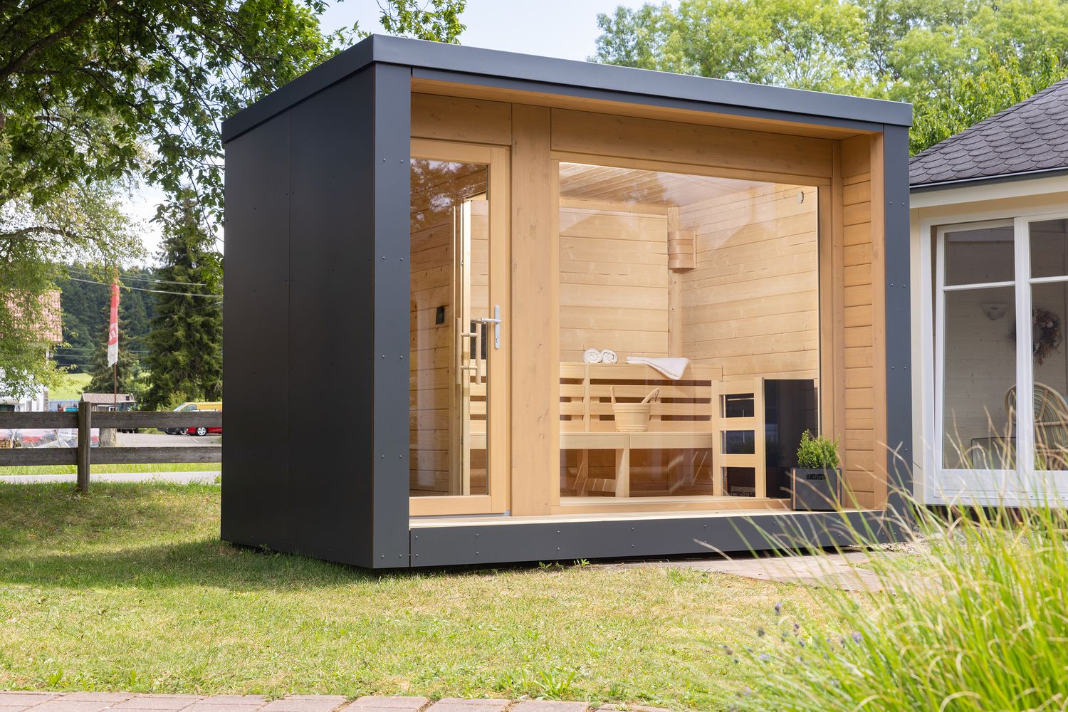 Luxuriöses Gartensauna-Modell mit großzügiger Glasfront und anthrazitfarbenen Fassadenplatten – verbindet modernes Design mit Funktionalität.