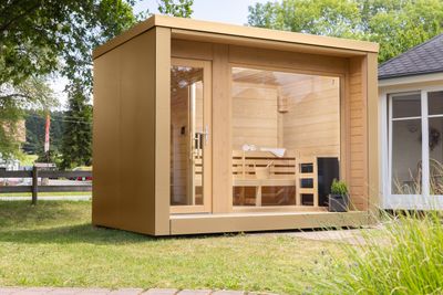 Design-Saunahaus mit hochwertiger HPL-Verkleidung in Sand- und Brauntönen, flachem Dach und großzügiger Fensterfront – ideal für moderne Gartenlandschaften.