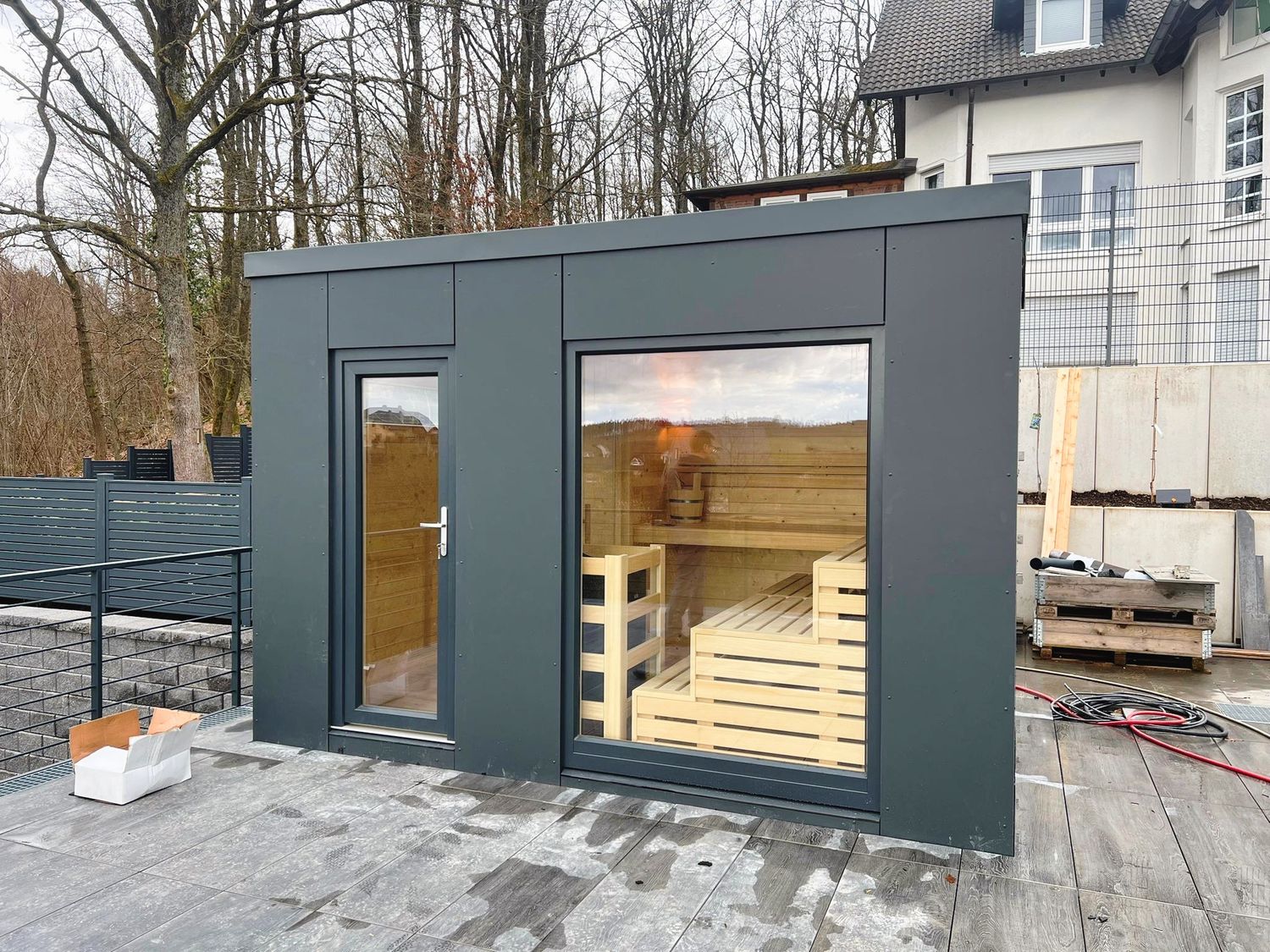 Luxuriöse Outdoor-Massiv Gartensauna SaunaBloox mit anthraziter HPL-Verkleidung und Flachdach