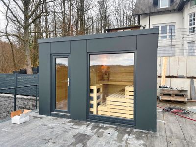 Luxuriöse Outdoor-Massiv Gartensauna SaunaBloox mit anthraziter HPL-Verkleidung und Flachdach