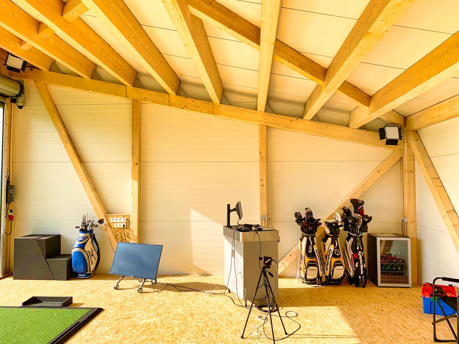 Innenraum einer Indoor-Golfhalle – isolierter Boden mit Abschlagfläche und Netzschutz