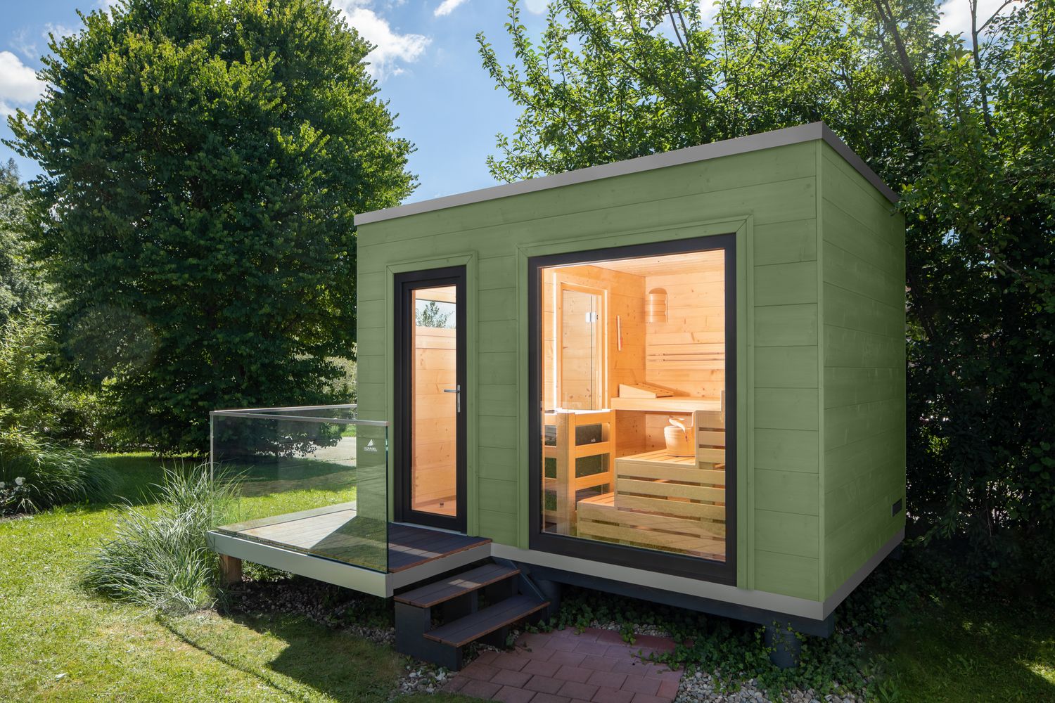 Modernes Saunahaus mit Flachdach und grüner Komodo-Lasur, klare Kubusform und Holz-Aluminium-Fenstern – ein stilvoller Rückzugsort für den Garten.​