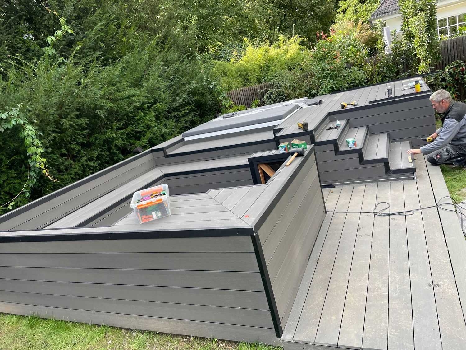 Luxuriöse Whirlpoolumrandung aus WPC mit Sitzbank und Feuerstelle