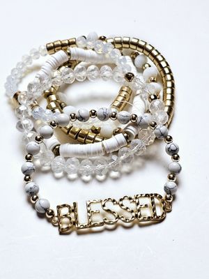 Radiant Harmony Bracelet Set, a stunning collection of bracelets featuring marbled white beads, clear faceted accents, and sleek gold details. The highlight of the set is a bold, gold-toned &quot;BLESSED&quot; charm, serving as both a fashionable statement and a reminder of gratitude and positivity. Perfect for stacking or wearing individually, these bracelets are versatile accessories that bring a touch of elegance and inspiration to any outfit.